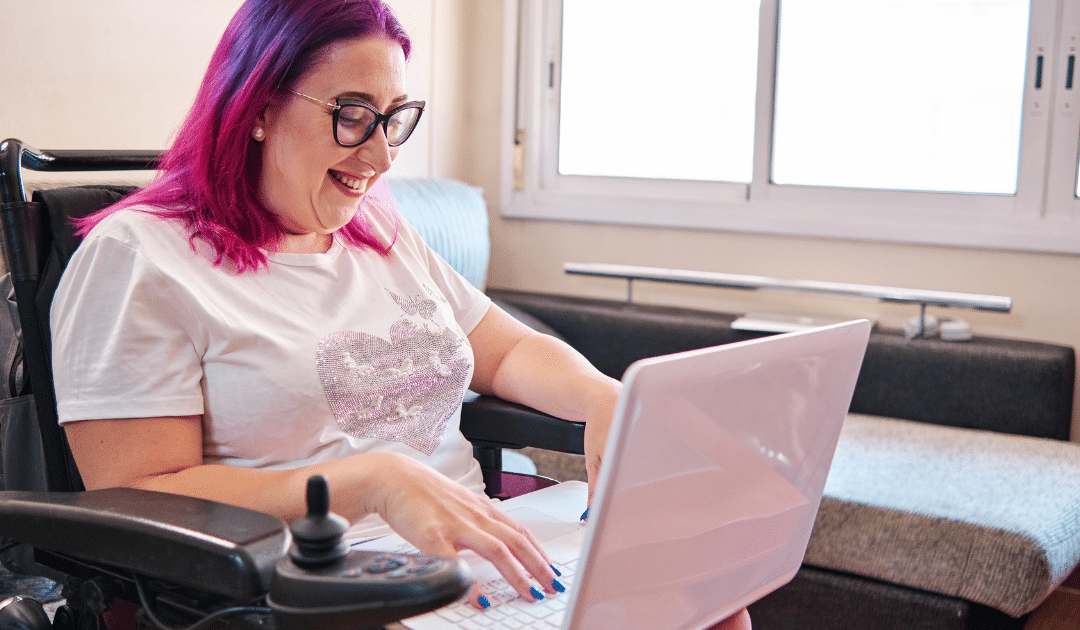 A woman in a wheelchair working on a laptop